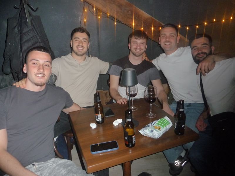 Grupo de amigos en una mesa bajo guirnaldas de luces