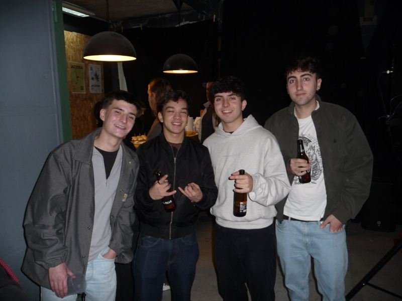Cuatro amigos con cervezas junto a los carteles de Jazzfera