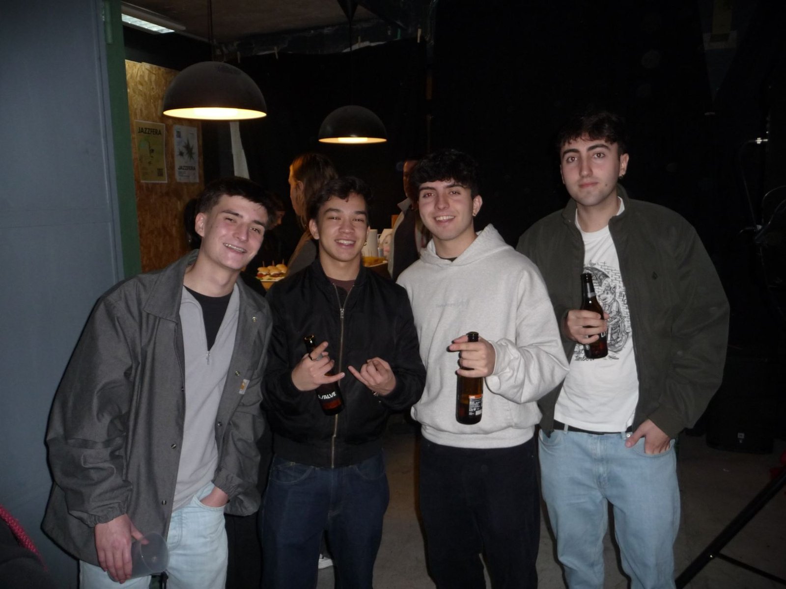 Cuatro amigos con cervezas junto a los carteles de Jazzfera